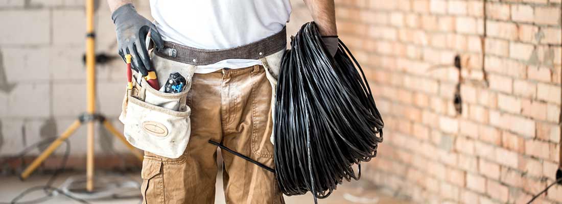 Image of electrician fixing wires on a ceiling.